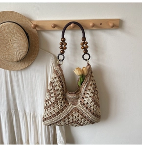 Detail of woven hobo bag with contrast diamond pattern and decorative wooden beads