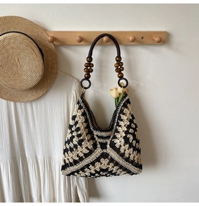 Detail of woven tote bag with wooden bead handle and geometric crochet patterns