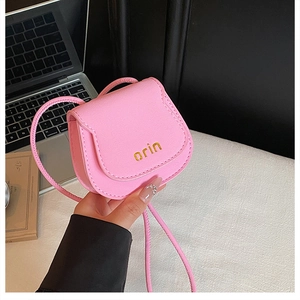 Close-up of pink mini saddle bag in litchi leather with gold embossed orin branding