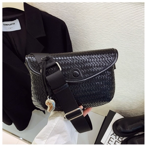 Détail du sac bandoulière tissé noir avec rabat et pendentif coeur en argent brillant