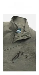 Close-up of OUTDOOR mountain embroidery on army green fishing vest ripstop fabric