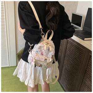 Détail d'un mini sac à dos matelassé blanc avec motifs d'animaux mignons et poche latérale
