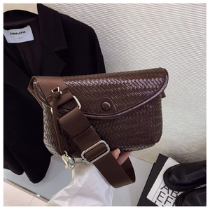 Détail du sac à bandoulière tressé marron foncé avec rabat et sangle en nylon réglable