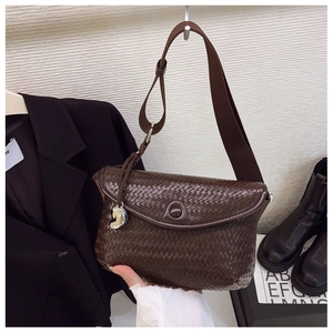 Détail du sac bandoulière tressé marron foncé avec boucle fer à cheval et sangle