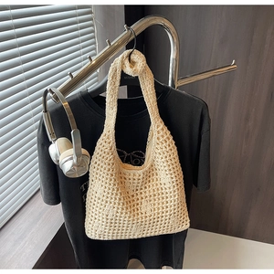 Gros plan du sac cabas au crochet crème avec texture tissée ajourée sur un cintre