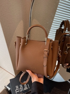 Brown lychee grain leather bucket bag with top handle and adjustable shoulder strap