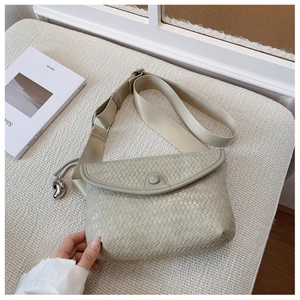 Détail du sac à bandoulière tissé vert sauge avec sangle large et pendentif goutte d'argent