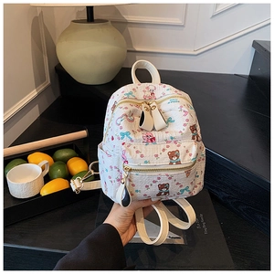 Détail d'un mini sac à dos blanc avec des imprimés d'ours et des fermetures éclair dorées