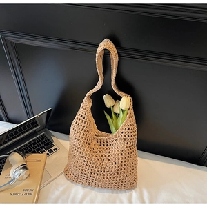 Gros plan du sac cabas en crochet beige avec motifs ajourés et doublure interne
