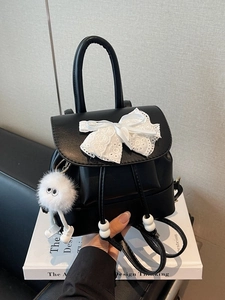 Mini black PU leather backpack featuring a white lace bow and plush pom-pom charm