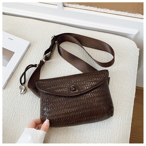 Vue détaillée de la texture tressée et du pendentif sur ce sac bandoulière marron