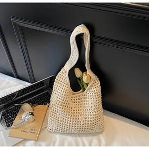 Gros plan sur un sac fourre-tout beige au crochet avec motif tricoté ajouré et doublure