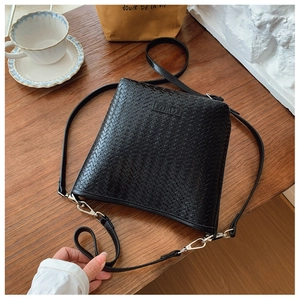 Détail du tissage noir sur sac seau avec logo embossé et boucle en métal argenté