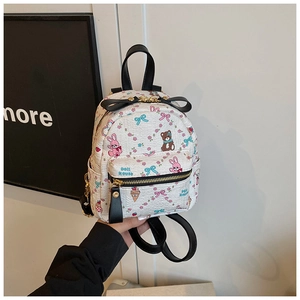 Vue détaillée des imprimés de dessins animés et du nœud sur le mini sac à dos blanc