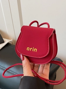 Mini red saddle purse with orin logo print and round strap shown in hand view