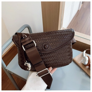 Détails de la texture tissée marron foncé avec large bandoulière et boucle en argent