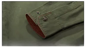 Dettaglio del polsino della camicia verde oliva con trama diagonale e bottone retrò
