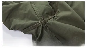 Dettaglio della cucitura a doppio ago rinforzata su tessuto per camicia verde oliva