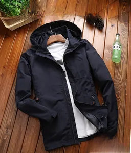 Detailansicht einer dunkelblauen Outdoor-Jacke mit Kapuze und Kordelzug auf Holzboden