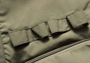 Detailed macro view of olive green tactical MOLLE webbing on durable outdoor vest material