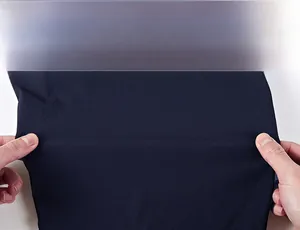 Close-up of dark blue quick-dry fabric being stretched to show high elasticity and texture