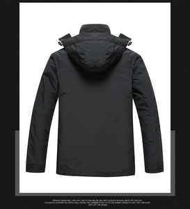 Rear view of black outdoor jacket featuring a detachable hood and adjustable velcro cuffs
