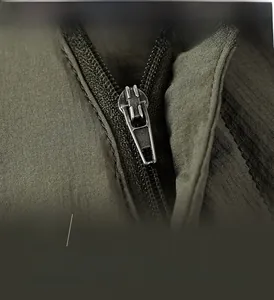 Detailed macro view of high-quality metal zipper on olive green ripstop outdoor shorts