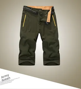 Detail of army green quick-dry shorts with yellow zipper pocket and orange waist lining