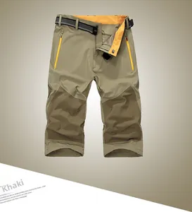 Detail of khaki quick-dry cargo pants with contrast knee patches and yellow zippers