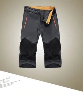 Detail view of quick-dry sports shorts featuring grey contrast stitching and orange zippers