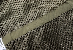 Macro detail of breathable olive green mesh fabric and reinforced stitching on vest