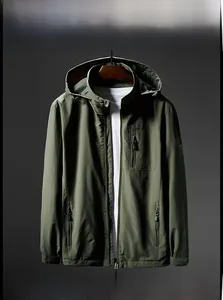 Detalle de chaqueta con capucha verde militar con bolsillos de cremallera y escudo en manga