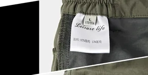 Detail view of quick-dry shorts waistband with fabric tag showing 87% nylon and 13% spandex