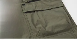 Detail view of olive green cargo shorts featuring reinforced flap pockets and zipper details