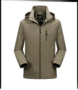 Detalle de chaqueta cortavientos caqui con diseño de capucha y bolsillo de pecho con cremallera