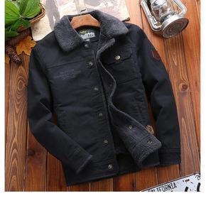 Outdoor cargo jacket detail with fleece collar and vintage patches on wood surface