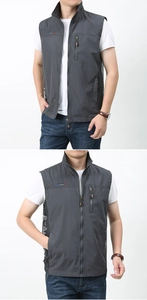 Detail of dark grey outdoor vest featuring breathable mesh side panels and zipper pockets