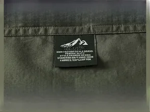 Détail du logo brodé extérieur sur une chemise cargo en coton vert olive durable