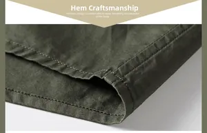 Close-up of the solid olive green shirt hem showing professional stitching and twill texture