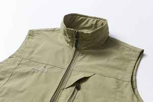 Détail du gilet extérieur avec col montant, fermeture éclair et broderie montagne