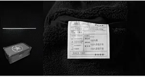 Detail of white cotton laundry label showing 100% cotton material on men jacket