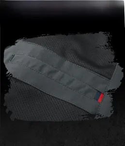 Detailed macro view of dark gray functional jacket fabric with small decorative ribbon