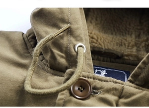 Detail view of khaki cotton jacket showing warm faux fur lining and metal tip drawstrings
