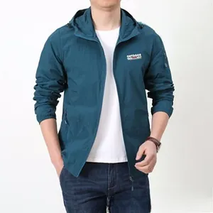 Détail d'une veste de protection solaire vert foncé légère avec logo outdoor et poche manche