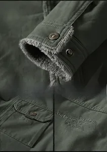 Detail of army green jacket with fleece lining, metal snaps and chest embroidery