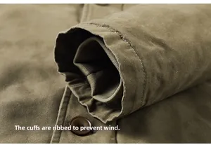 Detail of windproof ribbed inner cuffs and button on olive canvas work jacket