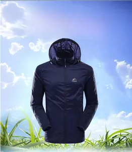 Detail of navy blue sun protection jacket with hood and mountain logo against sky background
