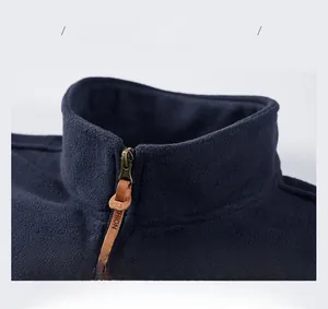 Detail of blue men's fleece vest featuring a stand collar and leather puller zipper