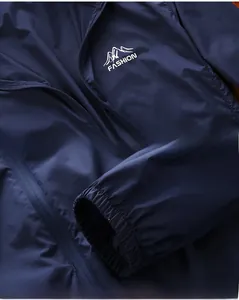 Detail of dark blue windbreaker featuring durable zipper and elastic cuffs for outdoors