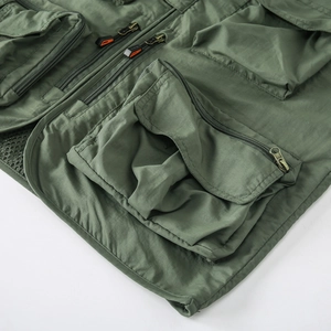 Détail du gilet de pêche vert armée avec plusieurs poches utilitaires et fermetures éclair